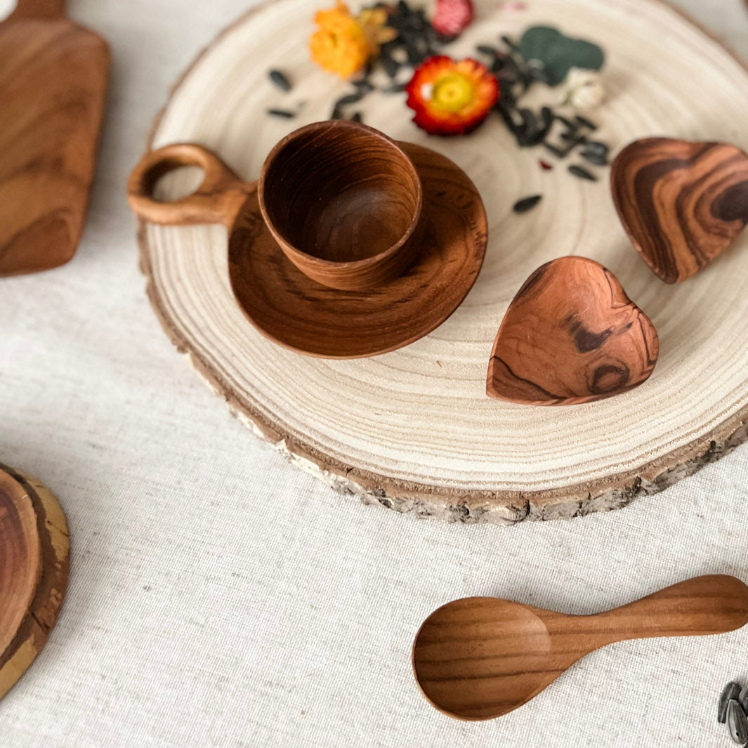 Wooden tableware set with decorative elements on a white surface