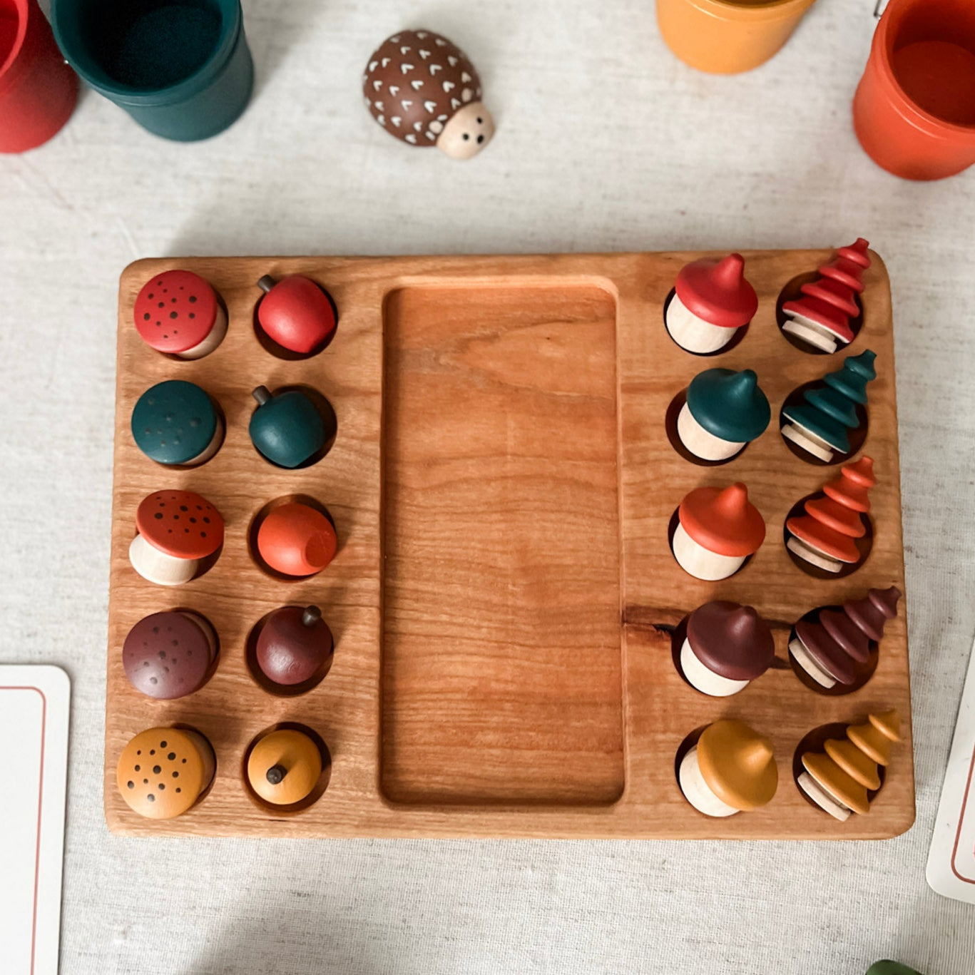 Wooden game board with colorful animal figurines on a light gray surface.