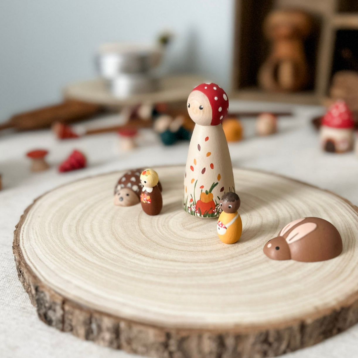 Small figurines on a wooden stand with a soft, blurred background