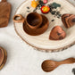 Wooden tableware set with decorative elements on a white surface