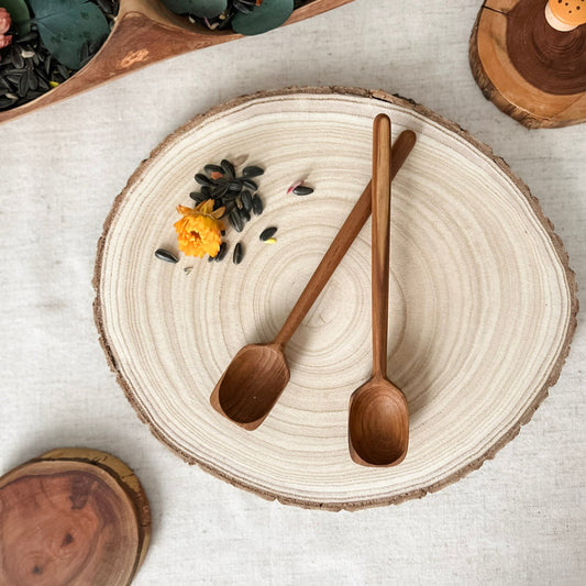 Wooden spoons on a ceramic plate with decorative elements on a light surface