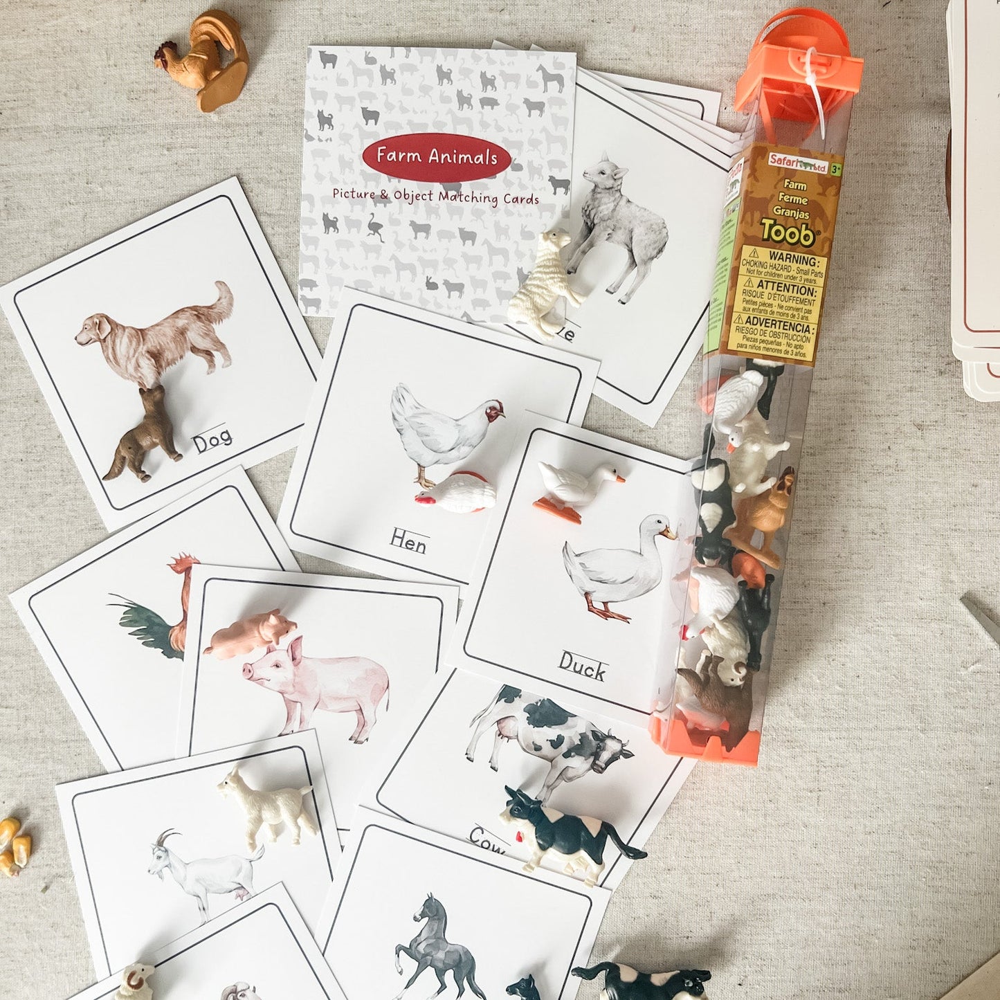 Educational farm animal cards with corresponding figurines on a textured surface